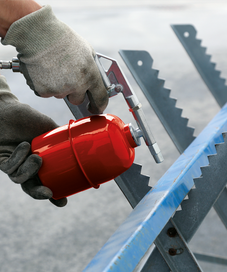 A person uses a spray gun with suction can