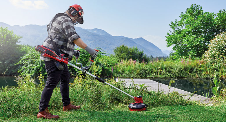 man is cutting the grass with a Einhell scythe